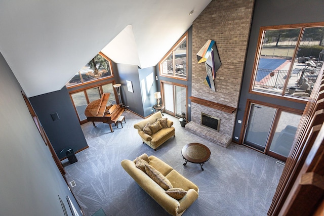 carpeted living room with a fireplace and high vaulted ceiling