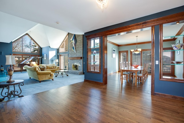 living room with a chandelier, a large fireplace, baseboards, and wood finished floors