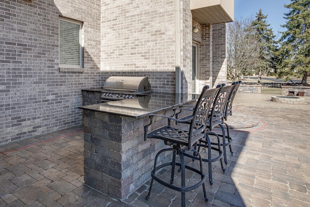 view of patio / terrace featuring an outdoor kitchen, fence, outdoor dry bar, and a grill