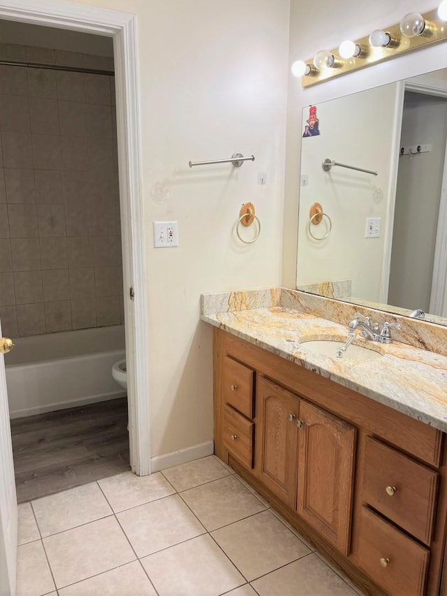 full bath with tile patterned floors, baseboards, toilet, and vanity