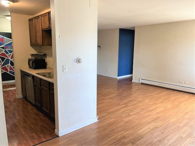 kitchen featuring dishwasher, a baseboard heating unit, black microwave, and wood finished floors