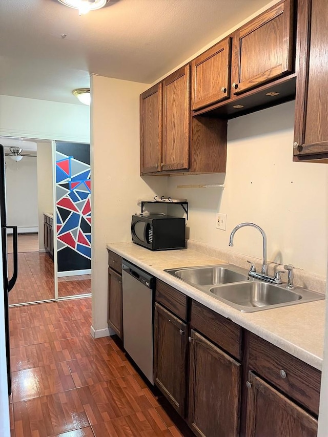 kitchen featuring a sink, dark wood finished floors, black microwave, light countertops, and dishwasher