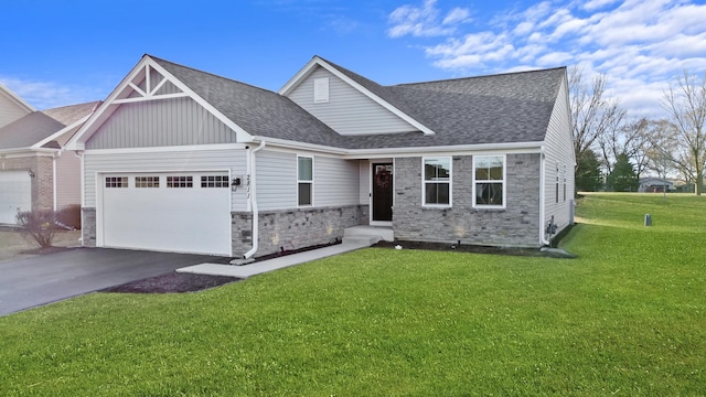 view of front of property featuring a front yard, roof with shingles, an attached garage, stone siding, and aphalt driveway