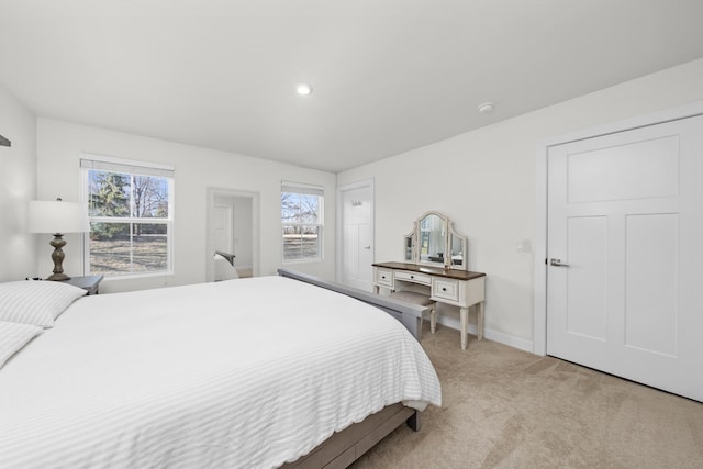 bedroom featuring light colored carpet and baseboards