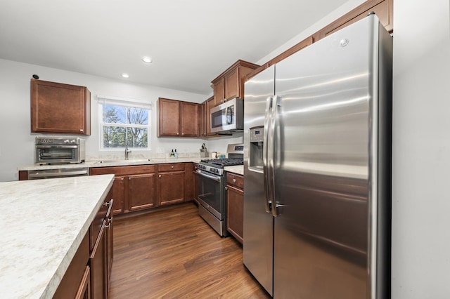 kitchen featuring a sink, recessed lighting, appliances with stainless steel finishes, light countertops, and dark wood-style flooring