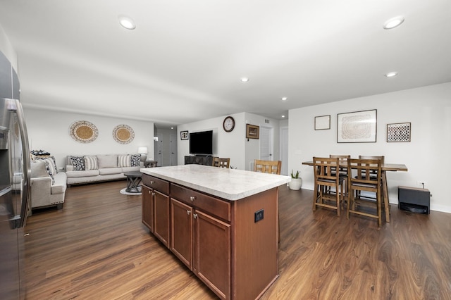 kitchen featuring a center island, open floor plan, dark wood-style flooring, and light countertops