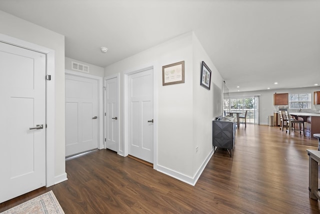 hall featuring recessed lighting, baseboards, visible vents, and dark wood-style flooring