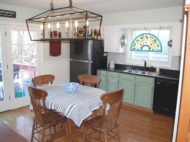 dining space featuring wood finished floors, a chandelier, and wainscoting