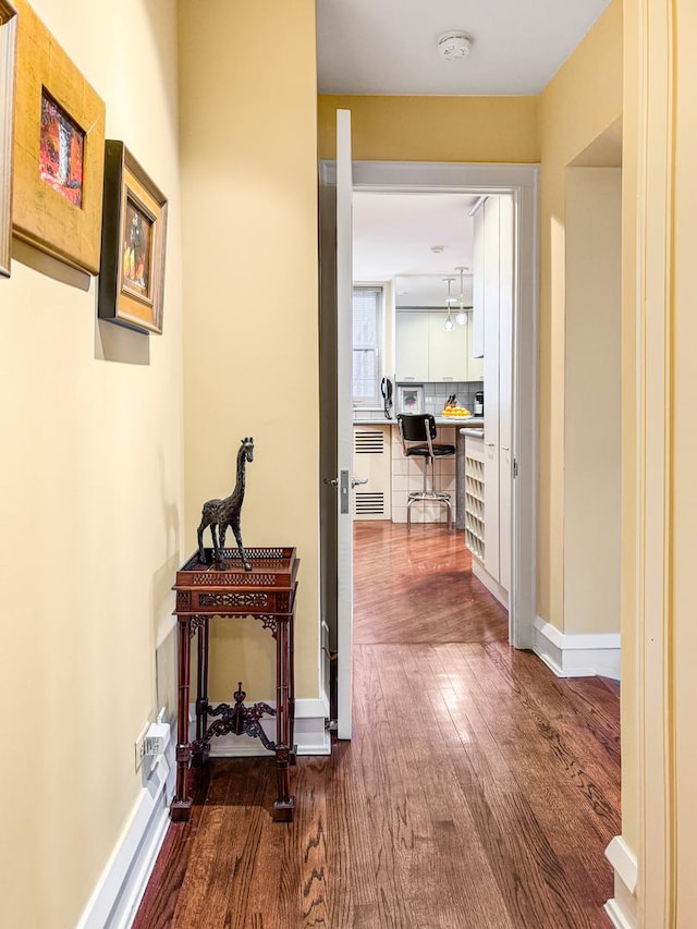 hallway featuring baseboards and wood finished floors