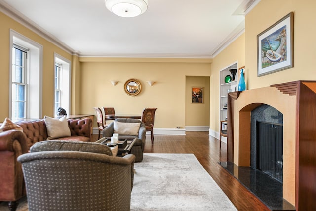 living area featuring crown molding, baseboards, dark wood finished floors, built in features, and a premium fireplace