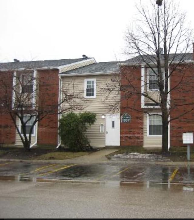 exterior space featuring a chimney and uncovered parking