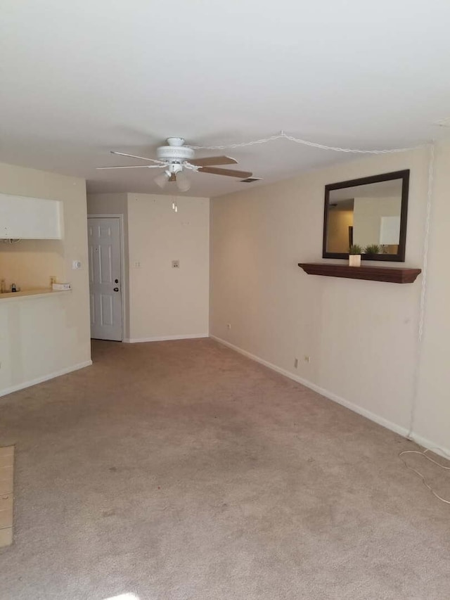 unfurnished living room featuring baseboards, carpet, and a ceiling fan