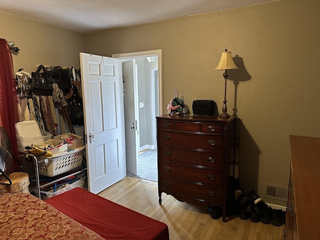 bedroom with light wood-style flooring and visible vents