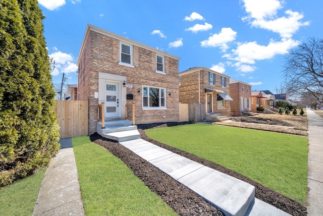 view of front of property featuring brick siding, a front yard, and fence