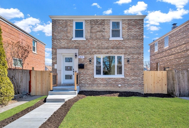 view of front of home with a front yard, fence, and brick siding