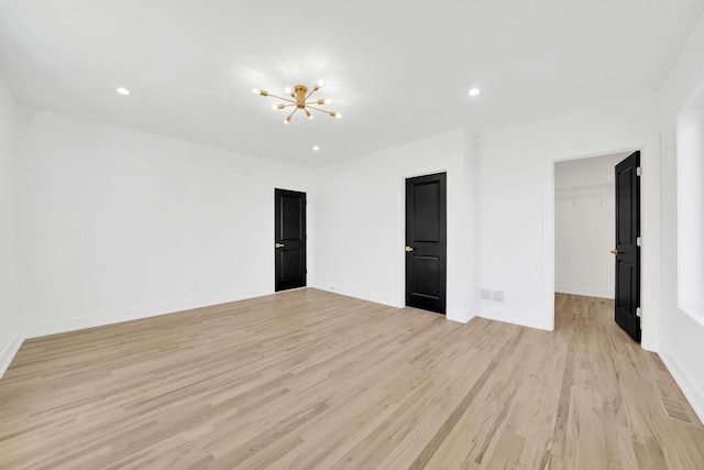 unfurnished bedroom with light wood-style flooring, a notable chandelier, recessed lighting, and visible vents