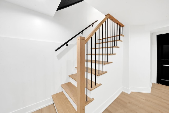 stairs with baseboards and wood finished floors