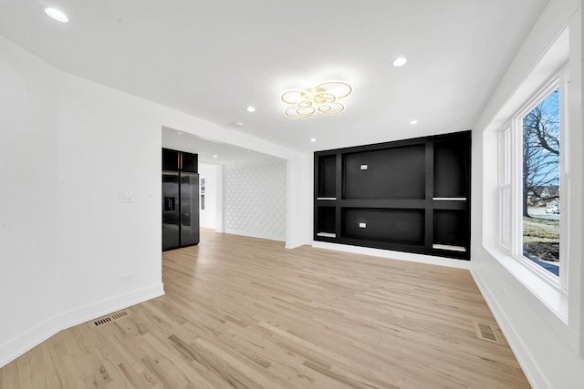 empty room with light wood finished floors, visible vents, recessed lighting, and baseboards