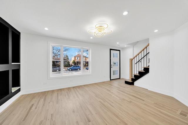 entrance foyer featuring visible vents, light wood-style flooring, and stairs