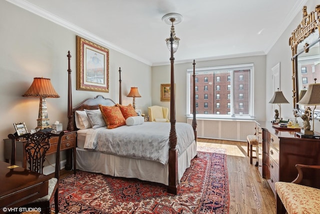 bedroom with multiple windows, radiator, ornamental molding, and wood finished floors