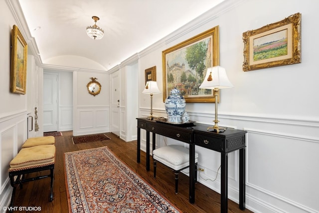 foyer entrance with a wainscoted wall, lofted ceiling, wood finished floors, and a decorative wall