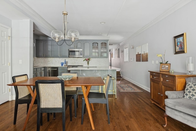 dining room featuring dark wood finished floors, baseboards, and ornamental molding