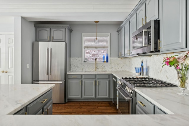 kitchen featuring appliances with stainless steel finishes, gray cabinetry, and a sink