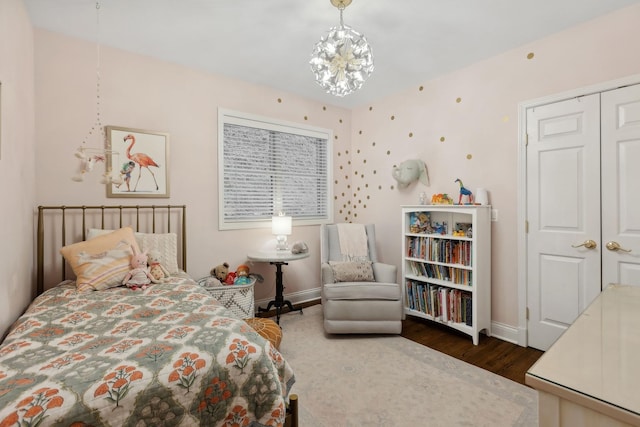 bedroom featuring a chandelier, baseboards, and wood finished floors