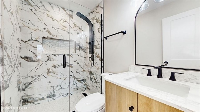 bathroom with a marble finish shower, toilet, and vanity