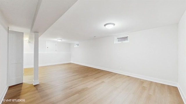 finished basement with baseboards and light wood-style flooring