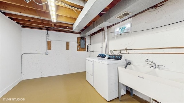 clothes washing area featuring laundry area, washing machine and clothes dryer, visible vents, and a sink