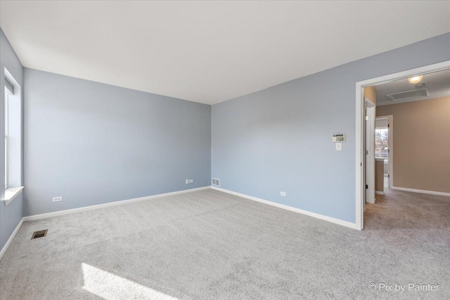 carpeted spare room featuring baseboards and visible vents