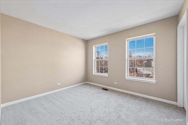 spare room with visible vents, baseboards, and carpet floors