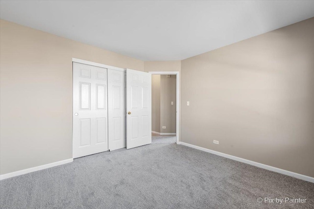 unfurnished bedroom with a closet, baseboards, and carpet