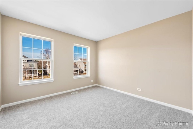 carpeted empty room featuring visible vents and baseboards