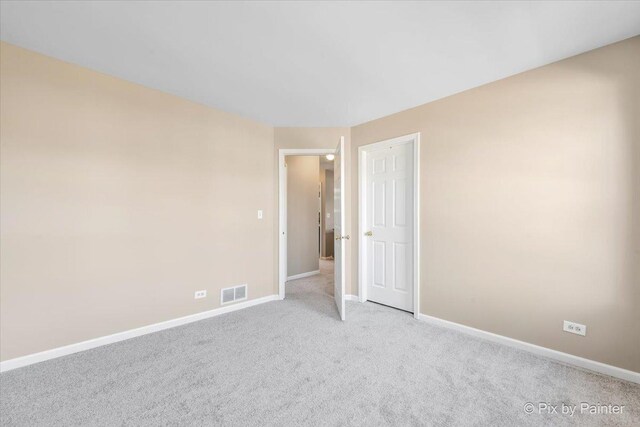 unfurnished room featuring visible vents, baseboards, and carpet