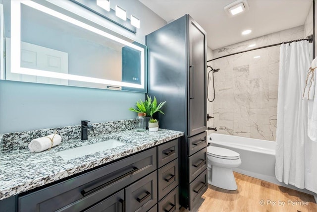 bathroom with vanity, shower / bath combination with curtain, toilet, and wood finished floors