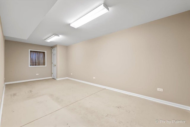 unfurnished room with baseboards and concrete floors