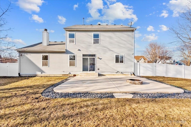 back of house with a patio area, a fenced backyard, a chimney, and a yard