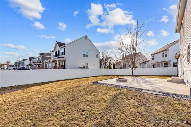 view of yard featuring a fenced backyard, a residential view, a fire pit, and a patio