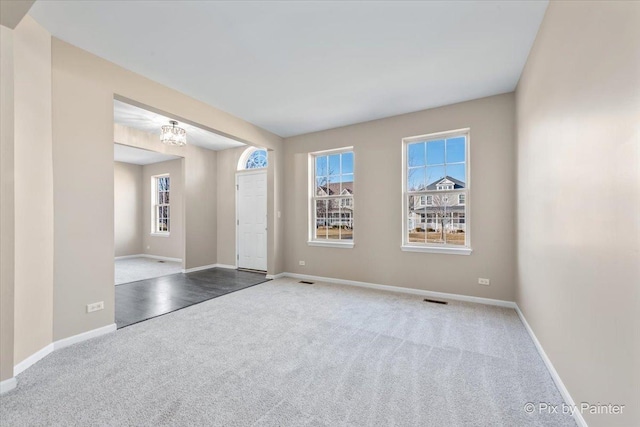 spare room with visible vents, baseboards, and carpet