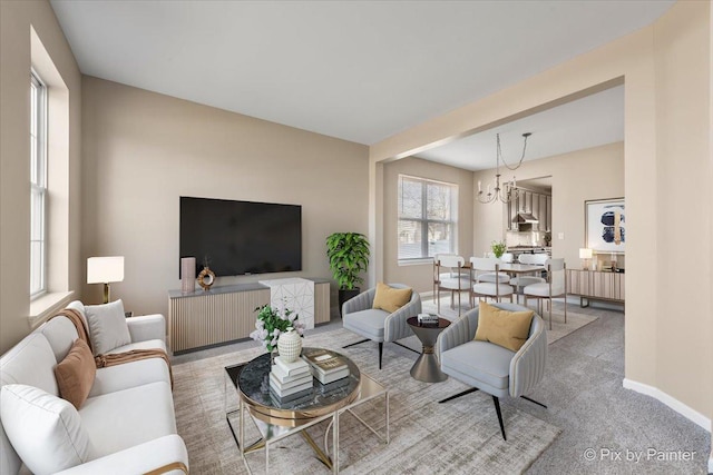 living room featuring a chandelier and baseboards