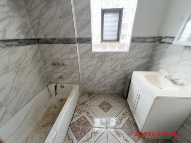 full bath featuring vanity and tile walls