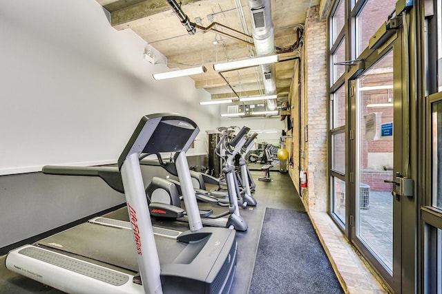 exercise room featuring brick wall