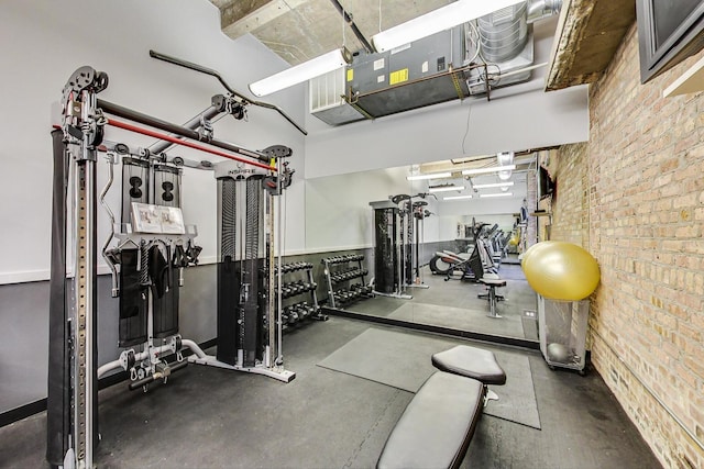 gym featuring brick wall and a garage