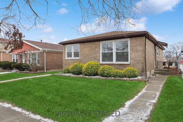 view of front of house with a front lawn and brick siding