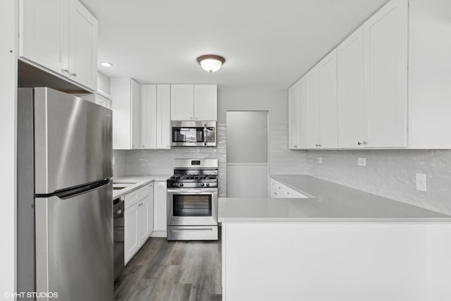 kitchen featuring white cabinets, a peninsula, and stainless steel appliances