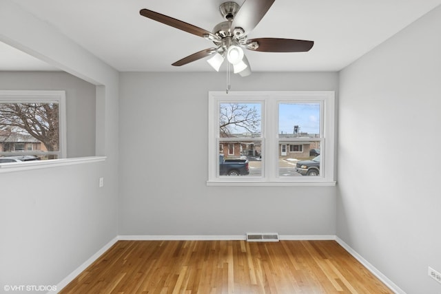 empty room with visible vents, baseboards, and wood finished floors