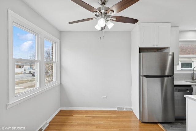 kitchen with white cabinetry, light wood-style flooring, visible vents, and stainless steel appliances