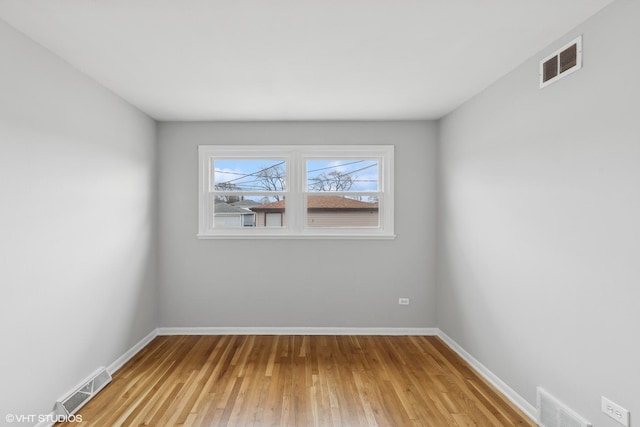 unfurnished room with light wood-style floors, visible vents, and baseboards